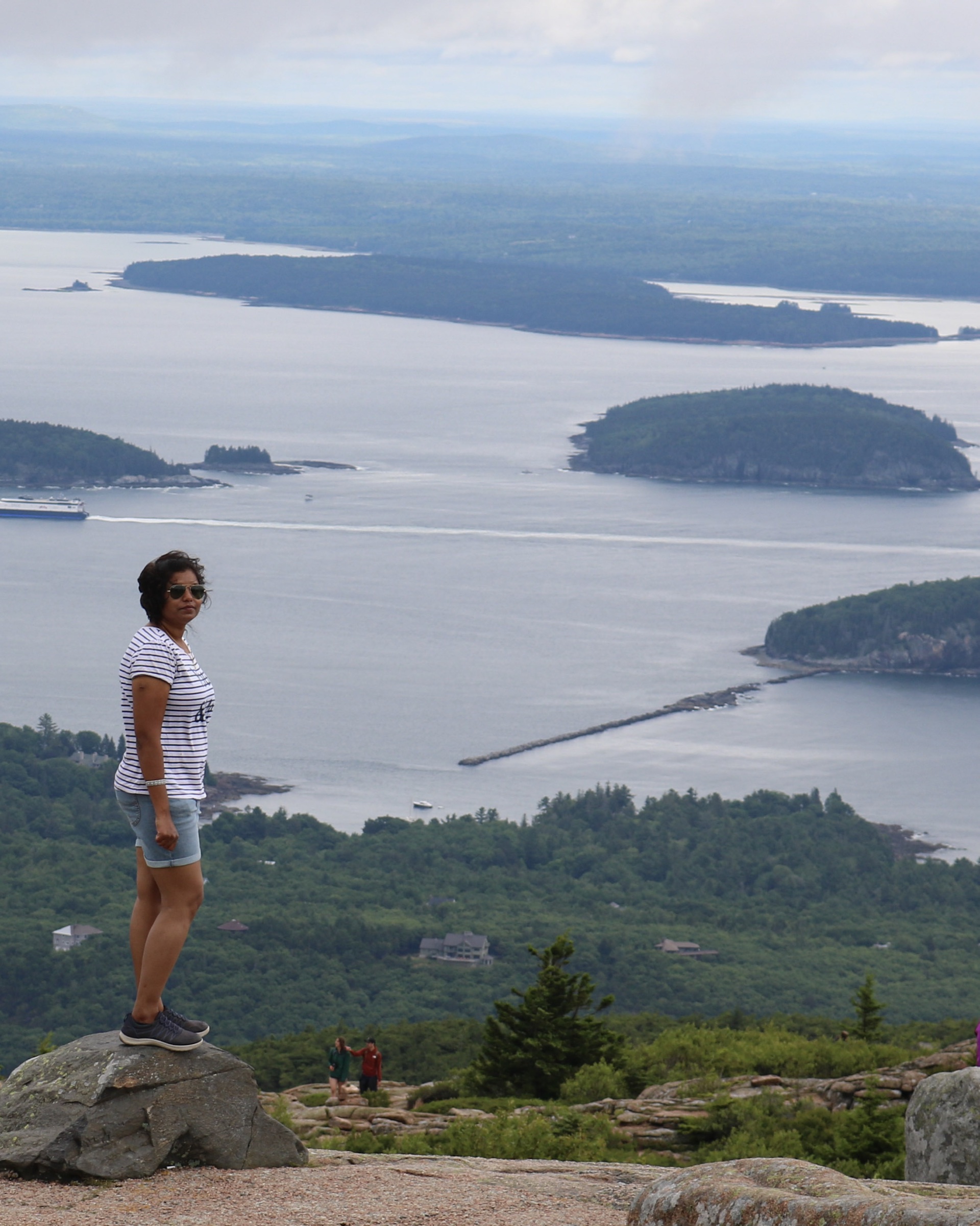 A traveler overlooking islands and coastal waters in Acadia National Park