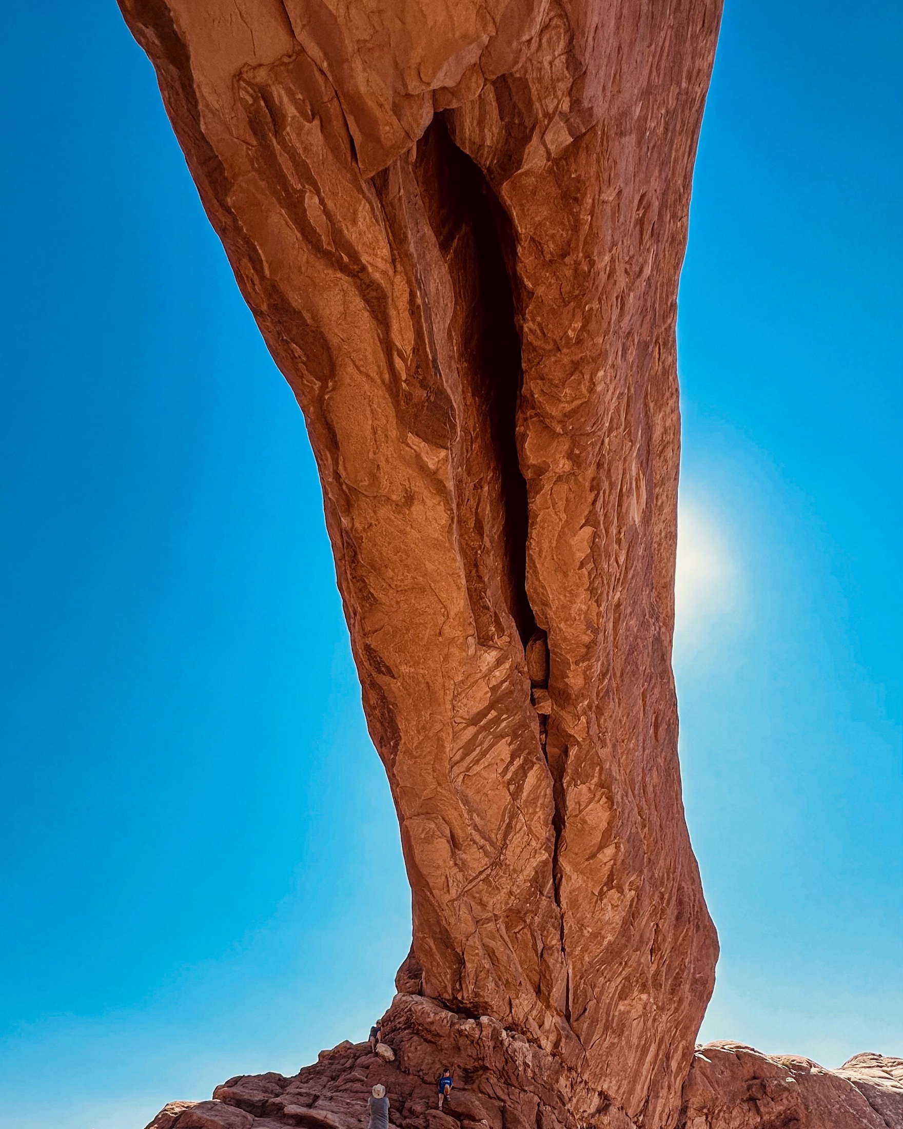 A narrow sandstone fin rising against a vivid blue sky