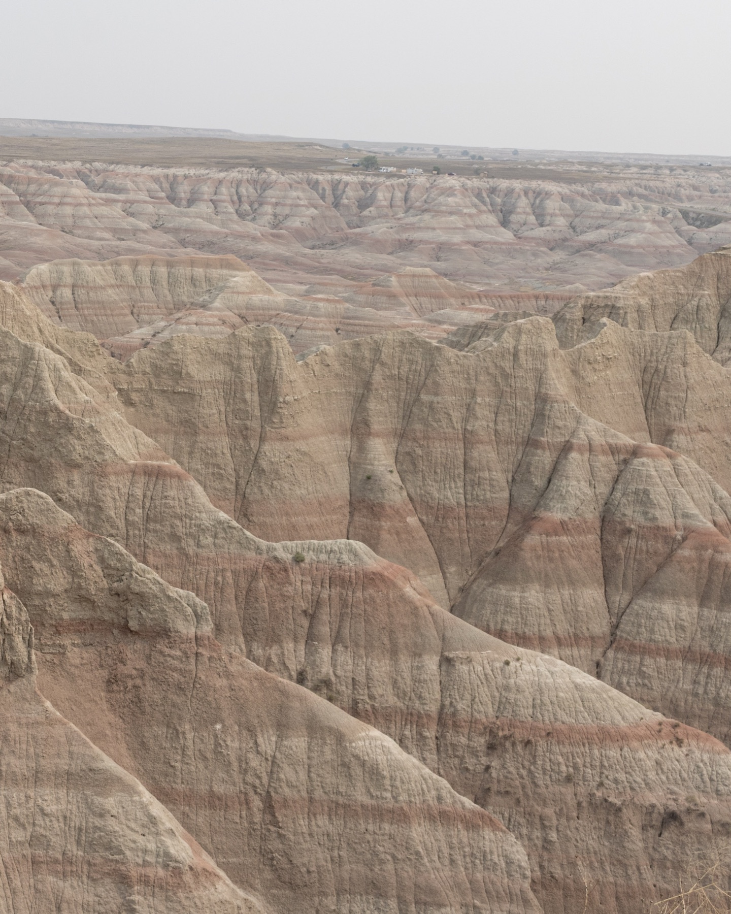 Pink and beige striped formations stretching across Badlands National Park