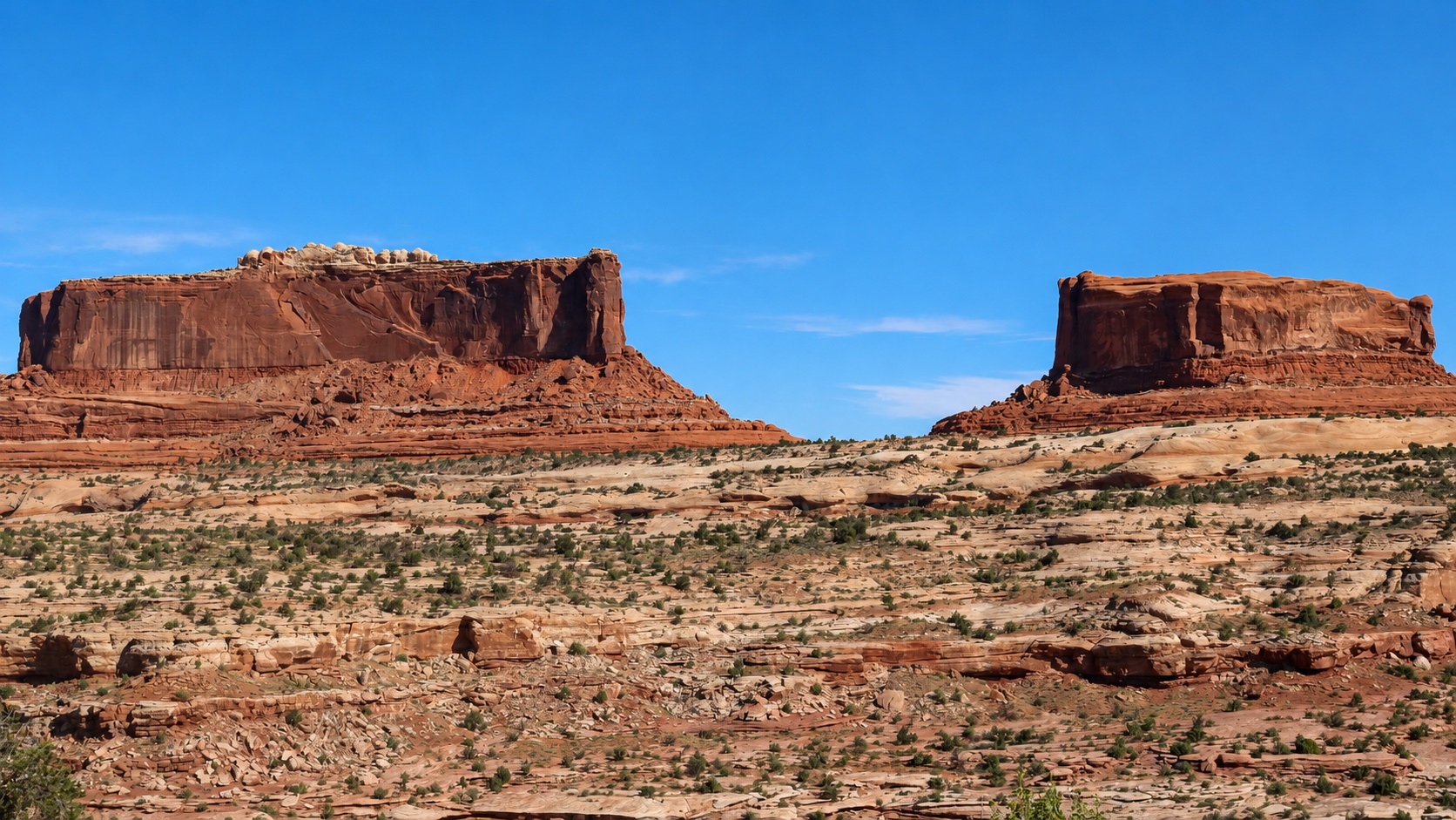 Twin red-rock mesas beneath a deep blue Utah sky